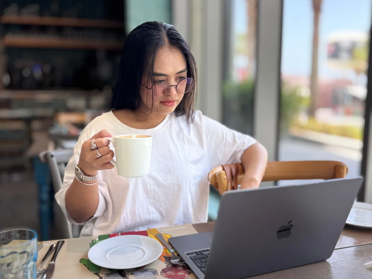 Person reading business email on a laptop over coffee